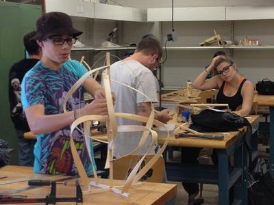 AACC art students work with wood.